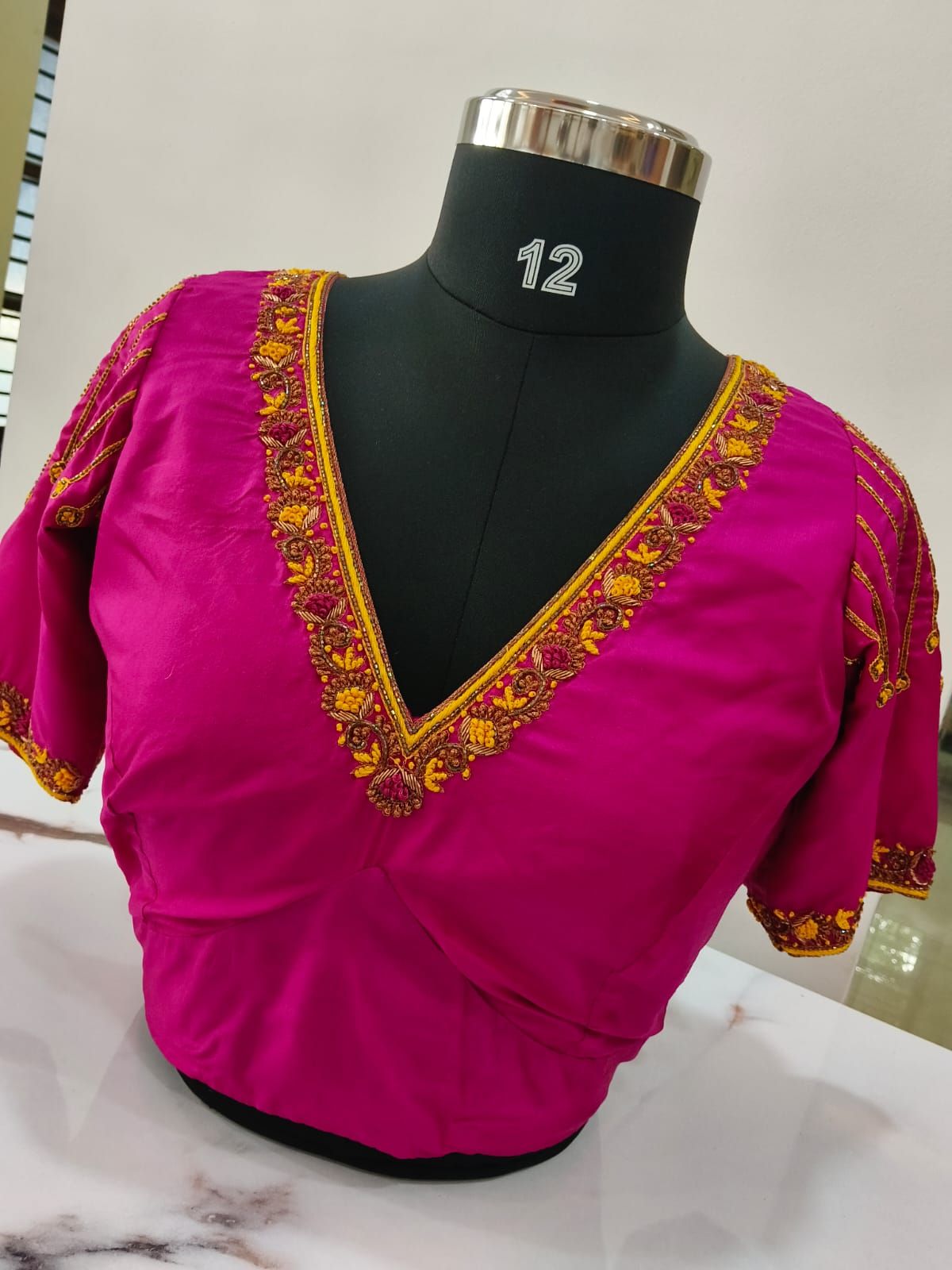 Fuchsia silk blouse with a deep V-neck edged in orange and gold floral embroidery