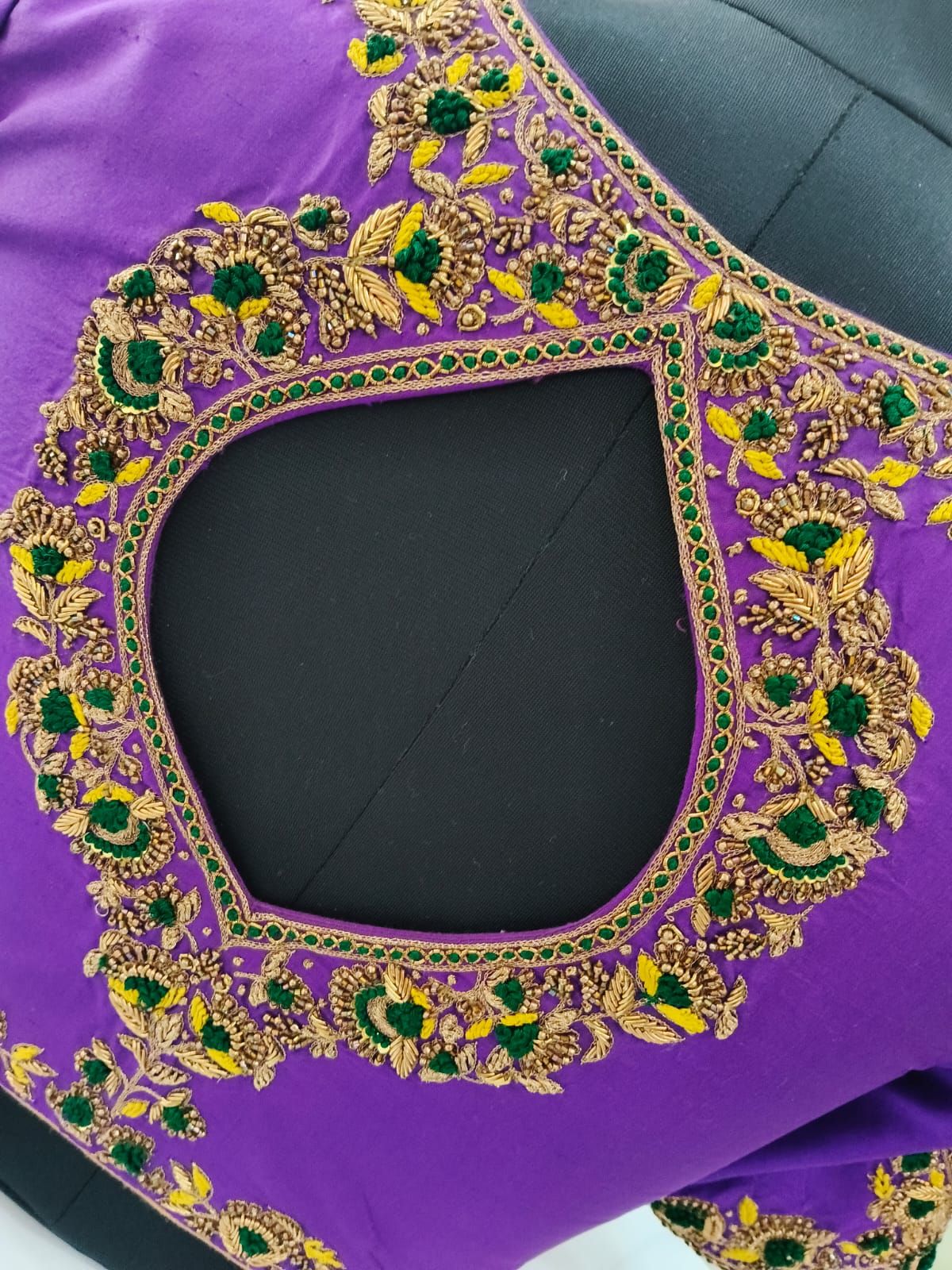 Detail of gold zardosi and green French knots around a keyhole opening